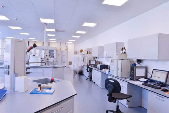 Young Male Scientist In Lab Pipetting On Science Bench Side