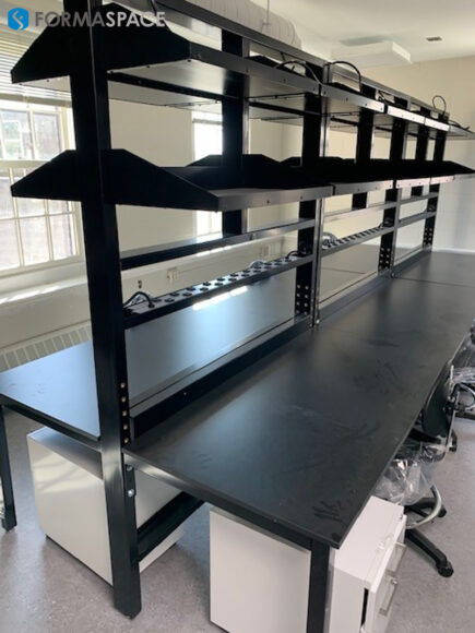 lab workstations connected to each other with upper shelving and electrical outlets
