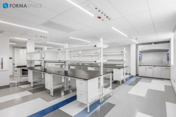 workstations for a wetlab with lower storage and upper shelving in white with black laminate tops and optional integrated electric