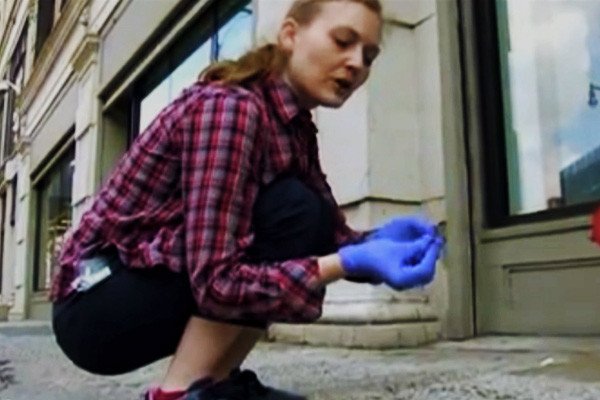 New York artist Heather Dewey-Hagborg bends down to collect a freshly discarded cigarette butt specimen from the sidewalk. It can be used to re-create an artistic recreation of the anonymous New Yorker's head. wpfc