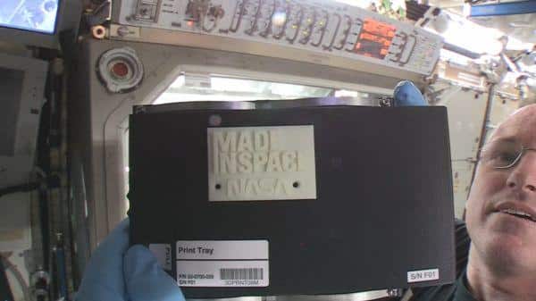 Astronaut Barry Wilmore shows off the first 3-D printed part in space inside the International Space Station.